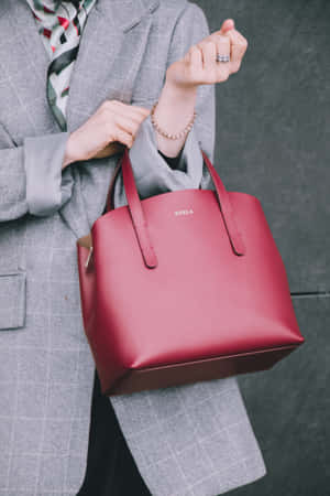 Stylish Red Handbag On Marble Surface Wallpaper