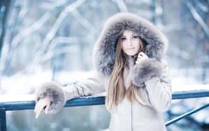 Stylish Woman In Chic Winter Outfit With Snowy Background Wallpaper