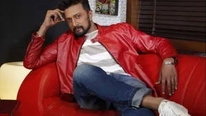 Sudeep On Plush Red Chair Wallpaper