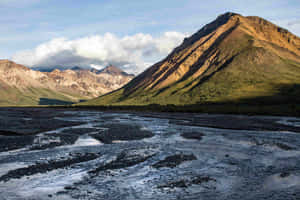 Sunlit_ Mountain_ Ridge_and_ Riverbed_ Alaska Wallpaper