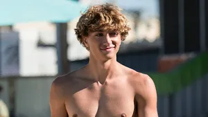 Sunny Beachside Young Man Smiling Wallpaper