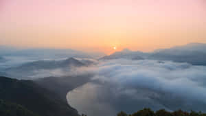 Sunrise Over A Lake With Clouds In The Background Wallpaper