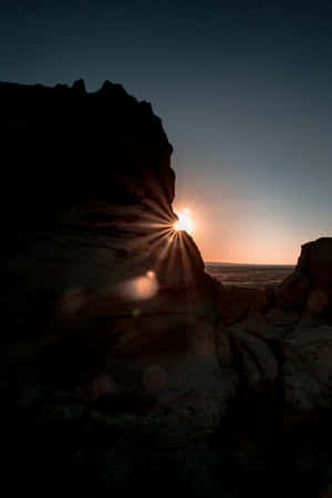 Sunrise_ Starburst_ Between_ Rocks.jpg Wallpaper