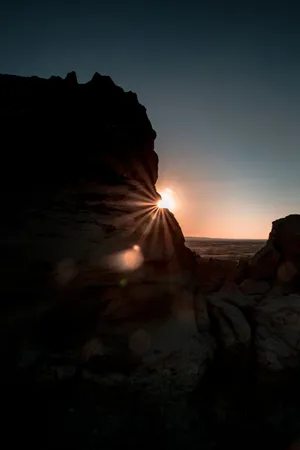 Sunrise_ Starburst_ Between_ Rocks.jpg Wallpaper