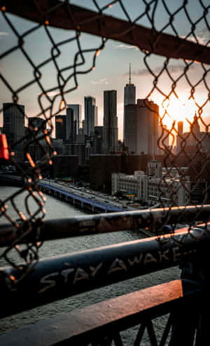 Sunset Cityscape Through Chainlink Fence Wallpaper