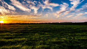 Sunset Over Green Farmland Wallpaper