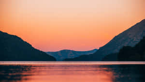 Sunset_ Serenity_ Lake_ Between_ Mountains.jpg Wallpaper