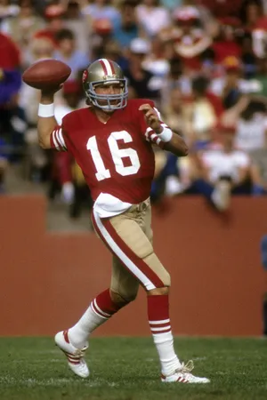 Super Bowl-winning Quarterback Joe Montana Leads The San Francisco 49ers Onto The Field In 1988 Wallpaper