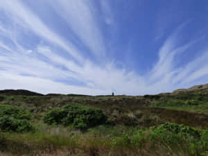 Sweeping Skies Above Dune Landscape Wallpaper