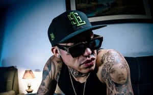 Tattooed Manin Black Capand Sunglasses Wallpaper