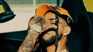 Tattooed Manin Car Covering Facewith Hand Wallpaper