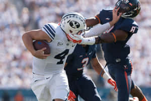 Taysom Hill Evading Tackle During Game Wallpaper