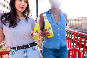 Teenage Girls Holding Yellow Soda Wallpaper