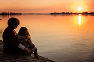 Tender Reciprocal Moment Between Mother And Daughter Wallpaper