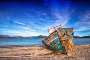 The Aging Beauty Of Isolation - A Rusty Boat Stranded Ashore Wallpaper