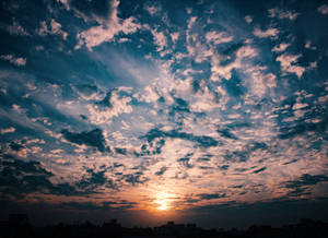 The Beauty Of A Golden Hour Sky, With A Backdrop Of Colorful Clouds. Wallpaper