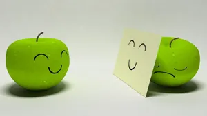 The Duality Of Emotions: Happy And Sad Apples Wallpaper