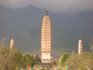 The Enchanting Three Pagodas Adorned With Colorful Prayer Flags Wallpaper