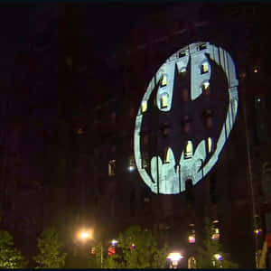 The Iconic Bat Signal Illuminating The Night Sky Wallpaper
