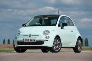 The Iconic Fiat 500 In Classic Design Cruising On The Open Road Wallpaper