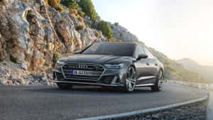 The Luxurious Audi S7 Speeding Through A Picturesque Landscape Wallpaper