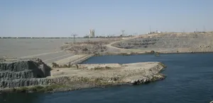 The Majestic Aswan High Dam Overlooking The Breathtaking Desert River Wallpaper
