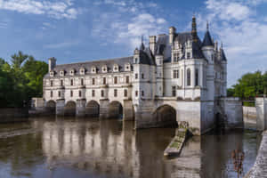 The Majestic Chenonceau Castle Over The Dark River Wallpaper