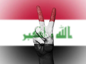 The Peaceful Power Of Iraq - A Hand Symbolizing Peace Covered With An Iraqi Flag. Wallpaper