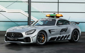 The Safety Car Leading The Race At Speed On The Track Wallpaper