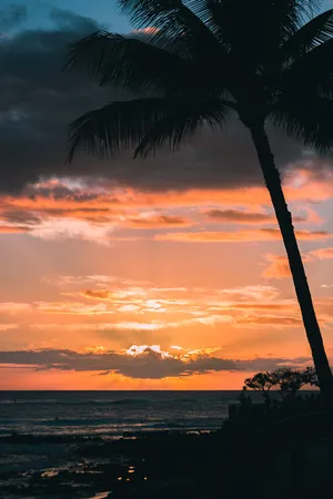 The Sun Setting Over A Stunning Beach In Hawaii Wallpaper