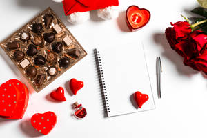 The Symbol Of Love: Romantic Flowers With Chocolates And A Notebook Wallpaper