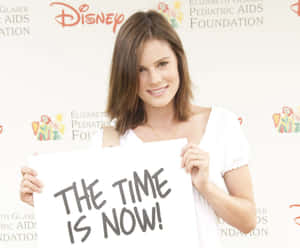 The Time Is Now Sign Holding Wallpaper