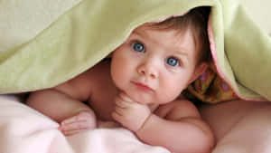 Thoughtful Baby Under Green Blanket Wallpaper