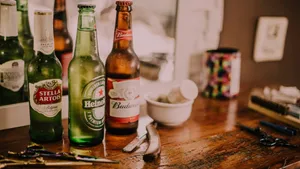 Three Different Alcohol Bottles Against A Mirror Wallpaper