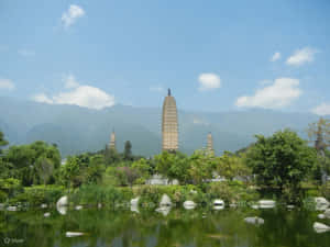 Three Pagodas With Rocks On River Wallpaper