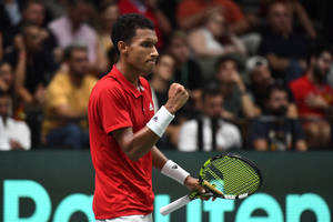 Thrilling Victory: Felix Auger Aliassime's Celebratory Fist Pump Wallpaper