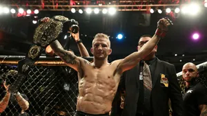 Tj Dillashaw Holding His Championship Belt Wallpaper