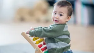 Toddler Playing With Abacus Toy Wallpaper