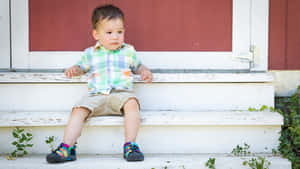 Toddler Sittingon Steps Outdoors Wallpaper