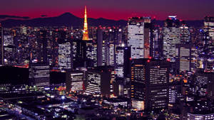 Tokyo Tower Stands Tall Amidst A Bustling Cityscape Wallpaper