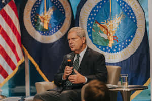 Tom Vilsack Giving An Inspirational Speech Wallpaper