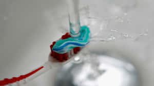 Toothbrush_with_ Toothpaste_and_ Water_ Stream Wallpaper