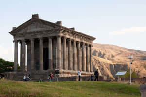 Tourists Exploring The Ancient Garni Temple In Armenia Wallpaper