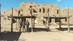 Tourists Exploring The Historic Taos Pueblo Wallpaper