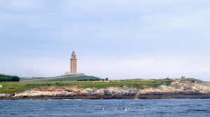 Tower Of Hercules Above The Ocean And Grass Wallpaper