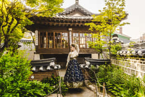 Traditional_ Korean_ Hanok_with_ Visitor_in_ Hanbok Wallpaper