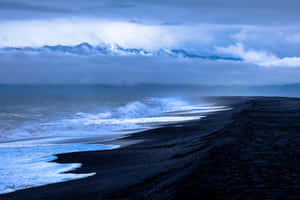 Tranquil Beach Waves Gently Kissing The Sandy Shore Wallpaper