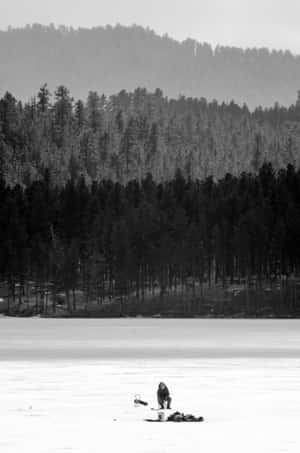 Tranquil Ice Fishing Scene At Sunset Wallpaper