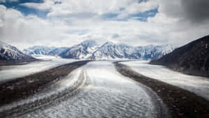 Tranquil Snow-covered Road In Winter Wallpaper