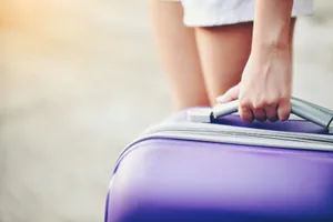 Traveler With Purple Luggage Wallpaper
